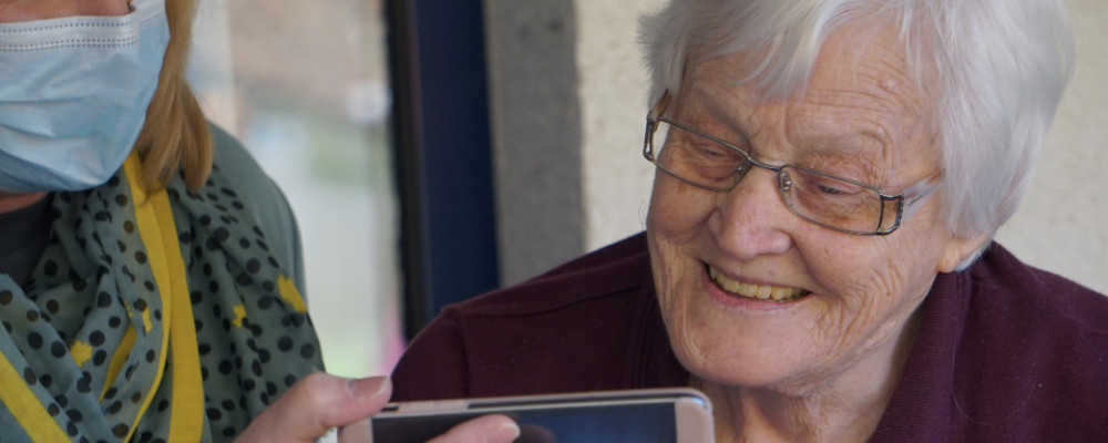 ältere Dame schaut etwas auf Handy
